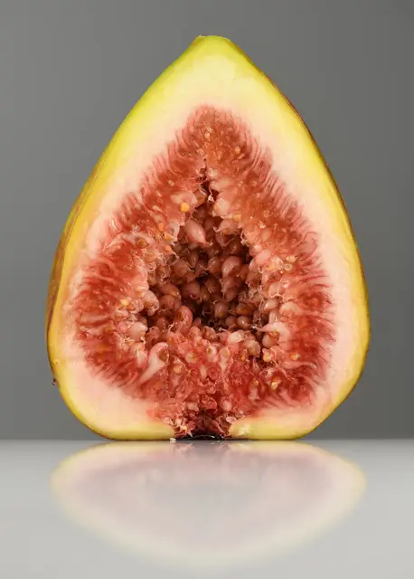 Fresh fig cut in half showing red seedy flesh